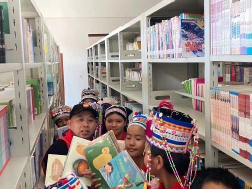 Children are choosing books in Sunrise Metal's library